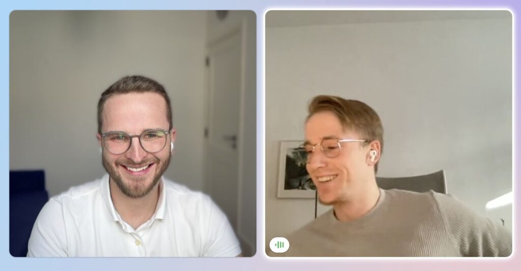 Max und Frederik nach dem ersten Abschluss: beide lächelnd, Handschlag im Büro vor dem Schreibtisch.